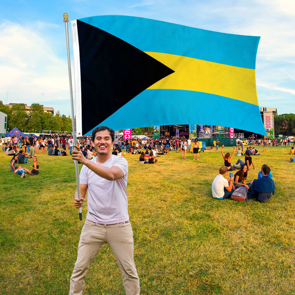 Man holding Bahamas  Printed Polyester Flag 3ft by 5ft on 6ft Hand Held Pole at outdoor festival